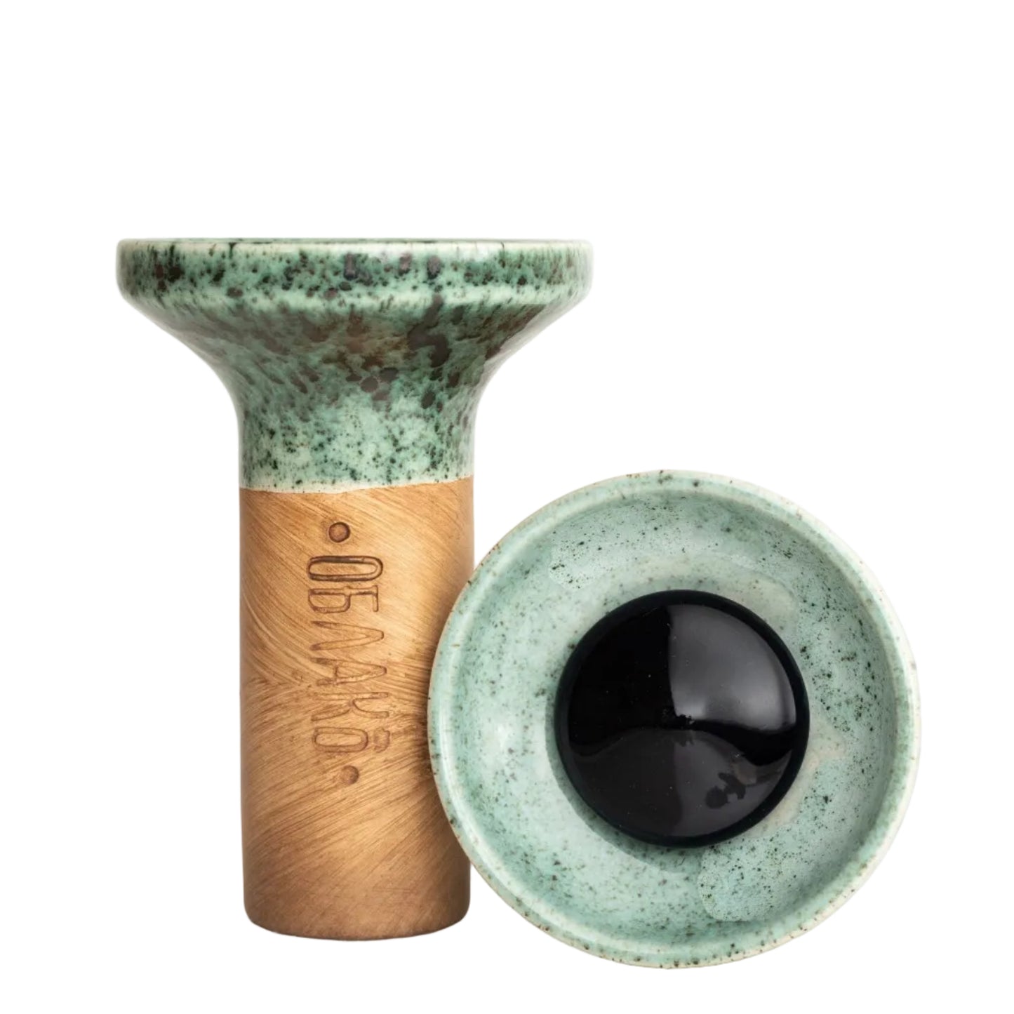 Ceramic eye-shaped object with green top and brown base on a white background
