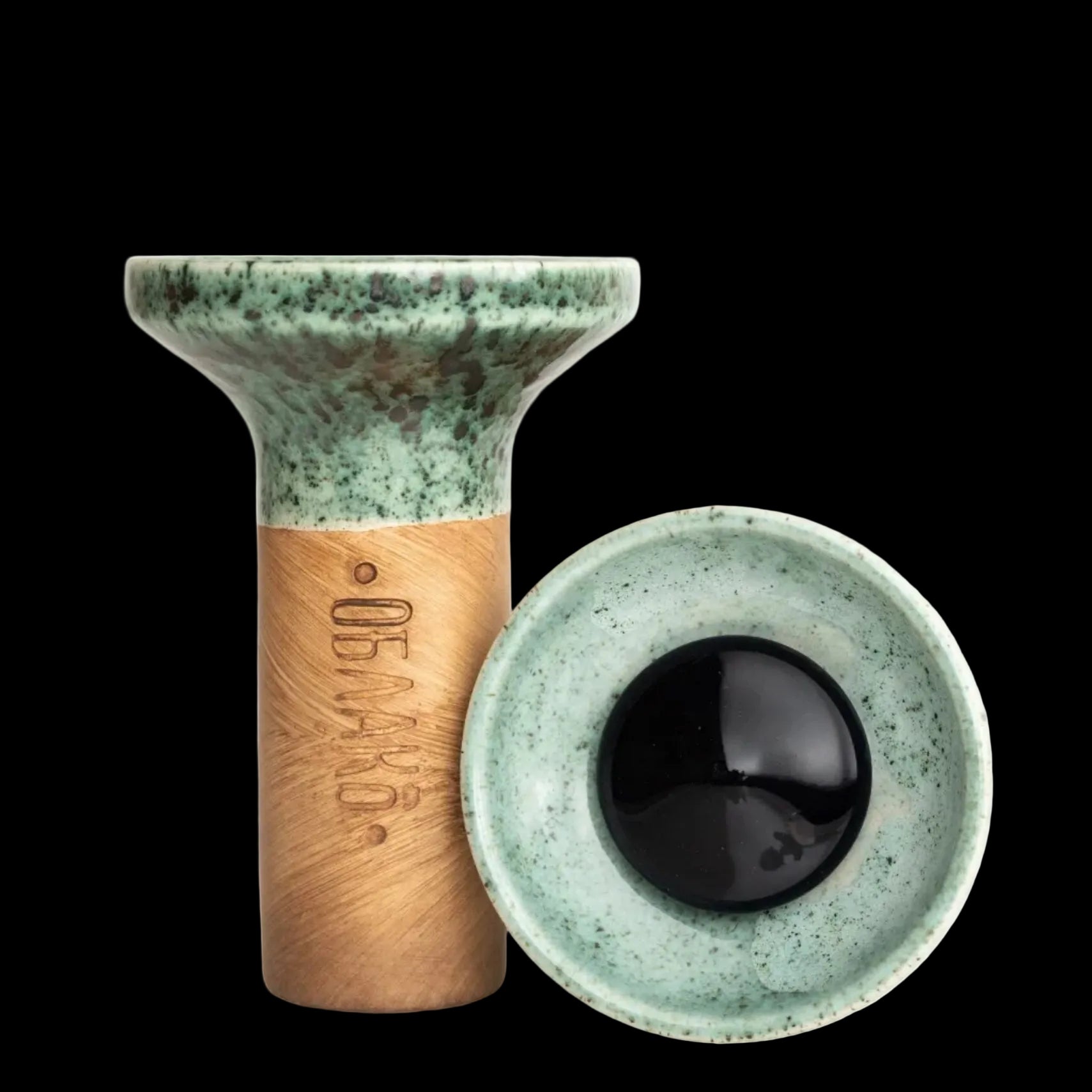 Ceramic eye-shaped object with green top and brown base on a white background